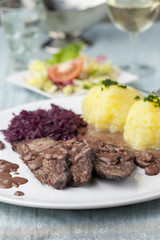 Sauerbraten mit Rotkohl auf einem Teller