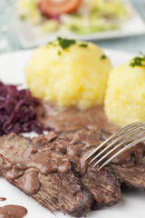 Sauerbraten mit Rotkohl auf einem Teller