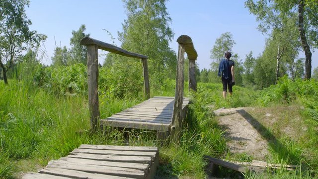Nature photographer, walking on a boardwalk - ProRes