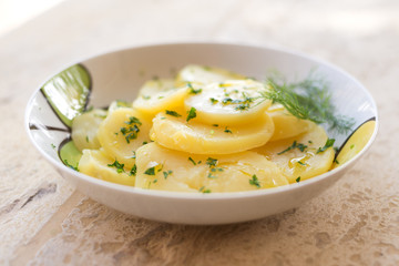 Insalata con fette di patate bollite e condite con olio e prezzemolo