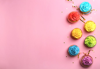 Delicious birthday cupcakes on color background