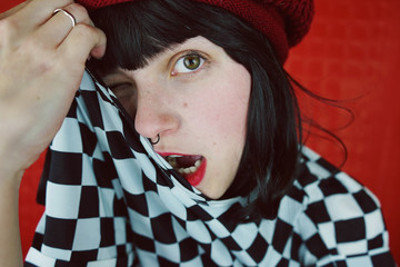Chica joven y alternativa posando sobre fondo rojo 
