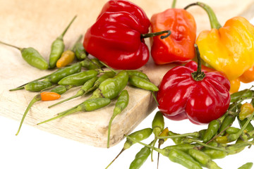 Bonnet and green chili peppers on a white background