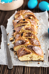 Homemade braided sweet bread with raisins on a wooden background
