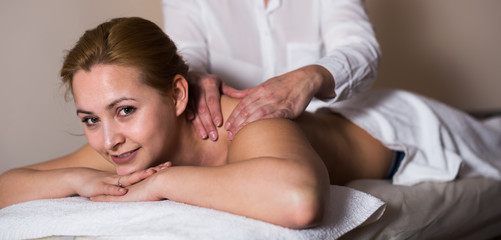 Obraz na płótnie Canvas Woman taking massage in salon