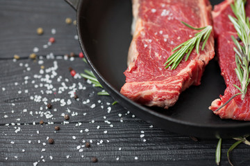 raw steak on cast iron frying pan