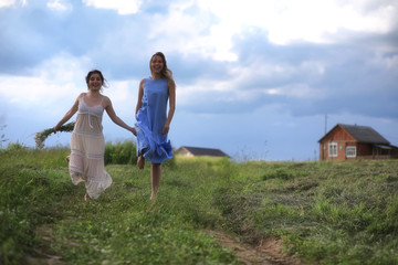 Fototapeta premium Young girls are walking in the field