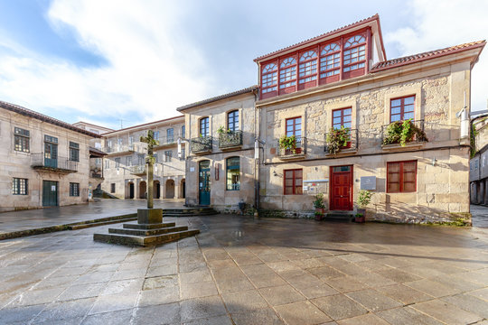Spanien - Historischer Platz Praza da Lena in Pontevedra in Galicien. Geb&auml;ude mit farbiger Fassade, Holzfenstern, Balkonen und einem Steinkreuz in der Mitte.