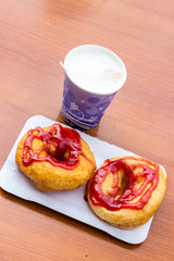 donuts whith jam on paper plate and coffee