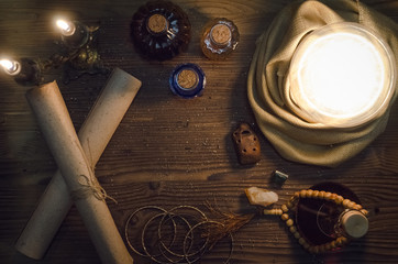 Crystal ball and ancient magic scrolls on fortune teller magic desk table background. Seance concept.