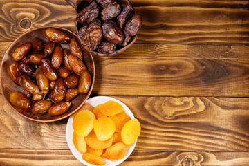 Dried apricots and dates fruit on wooden table. Top view
