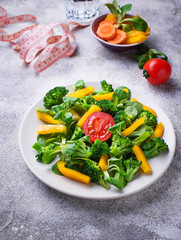 Healthy vegetable salad, water and measuring tape