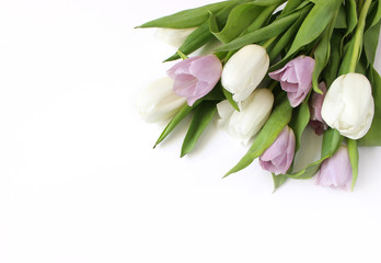 Spring styled stock photo. Easter concept. Feminine desktop scene with bouquet of white and violet tulip flowers on white table background. Empty space. Flat lay, top view.