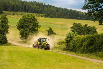 Traktor auf Feldweg an staubigen Sommertag © Raphael Koch