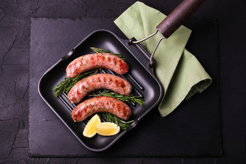 Grilled sausages with lime on iron grill pan