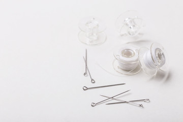 Sewing pins and plastic bobbin with white threads