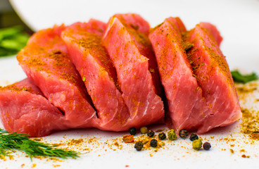 Pork fillet chopped spices on a white background.