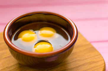 Raw chicken eggs in a plate .