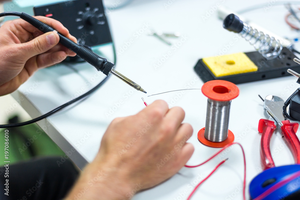 Wall mural Electrician soldering wires.