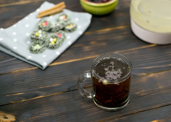 A cup with herbal tea and cookies on a dark background.