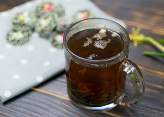 A cup with herbal tea on a dark background.