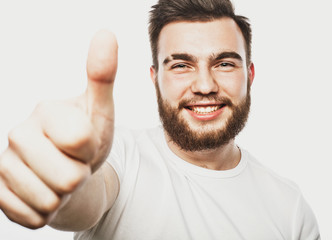 Portrait of a cheerful young bearded man showing okay gesture isolated on the white background