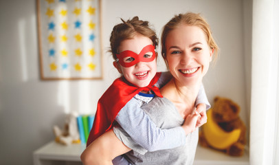 child girl in a super hero costume with mask and red cloak