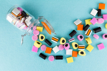 playful, colorful pile of candy liquorice allsorts spilling from jar