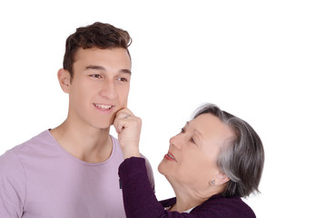 Grandmother kissing her teen grandson on the cheek