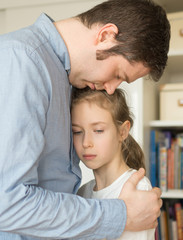 Sad little girl hugging her dad.