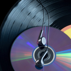 Vinyl plates, disks, headsets by close-up on a black background.