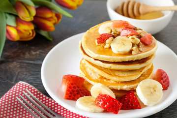 Healthy homemade breakfast with pancakes, strawberry, bananas nuts and honey