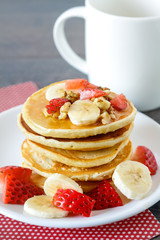 Healthy homemade breakfast with pancakes, strawberry, bananas nuts and honey