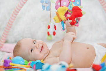 baby lying on Developing rug. playing in Mobile. educational toys. Sweet child Crawling And Playing...