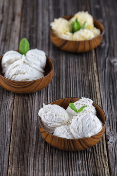 Vanilla ice cream with bowl on wooden background