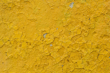 The texture wall of the old yellow cracked paint.