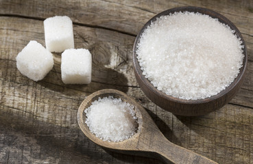 Fototapeta na wymiar White sugar in wooden bowl and spoon - cubes