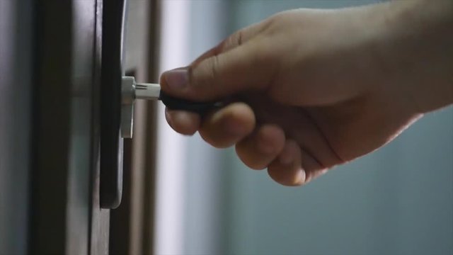 Locking up or unlocking door with key in hand