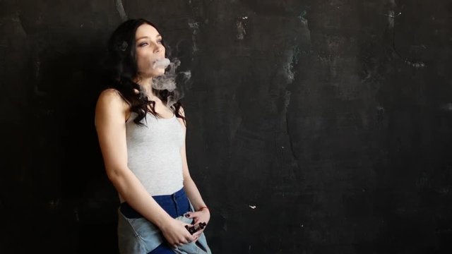 Close up of woman mouth smoking. The girl slowly and sexually releases smoke from an electronic cigarette