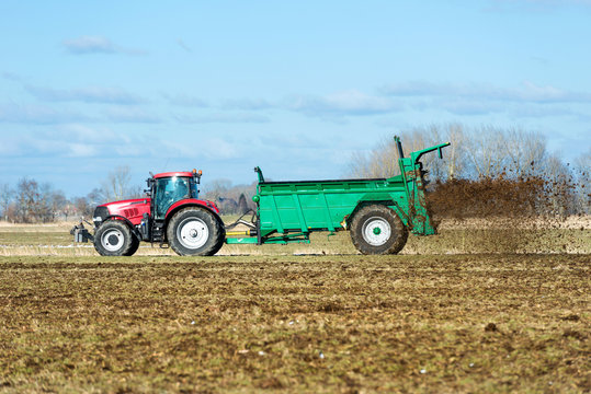Tractor with manure spreader on the field - 1379