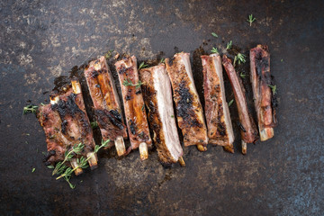 Barbecue spare ribs St Louis cut with hot honey chili marinade sliced as top view on an old rustic...