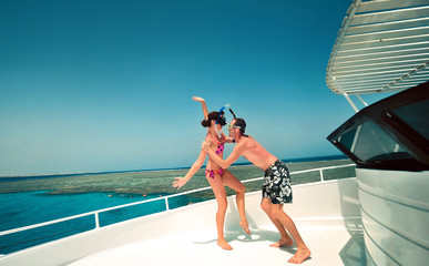 Happy young couple having snorkeling and beach fun on the yacht vacation honeymoon travel holidays. Caucasian woman and man playing playful enjoying love. Multiracial couple