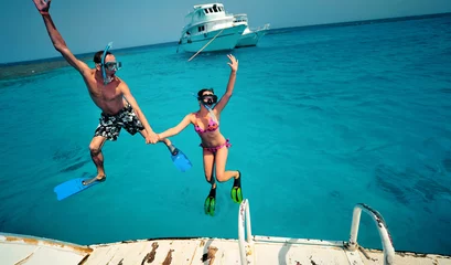 Foto op Aluminium Happy young couple having snorkeling and beach fun on the yacht vacation honeymoon travel holidays. Caucasian woman and man playing playful enjoying love. Multiracial couple © ANR Production
