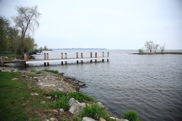 Fototapeta premium Dock and Lake - Wooden dock extends out into a waterway.