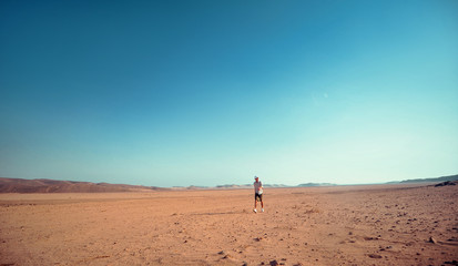 Fototapeta na wymiar Adventurous alone man in panama having fun and adventure watching the sunset walking in desert to thank life.