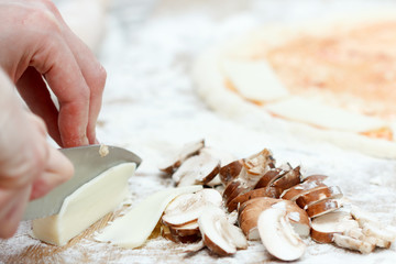 Woman cooking, slicing cheese on cutting board
