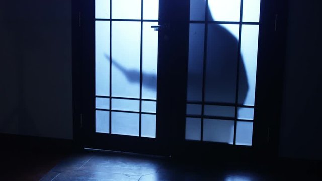 Killer or serial maniac with knife approaching to the door and entering to the room. Shot on RED Cinema Camera.