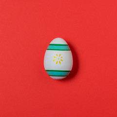 Colorful easter egg on red background. Easter minimal concept.