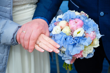 Bride and groom holding a bouquet of white and blue flowers