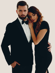 portrait of an elegant woman in a black dress hugging her lover